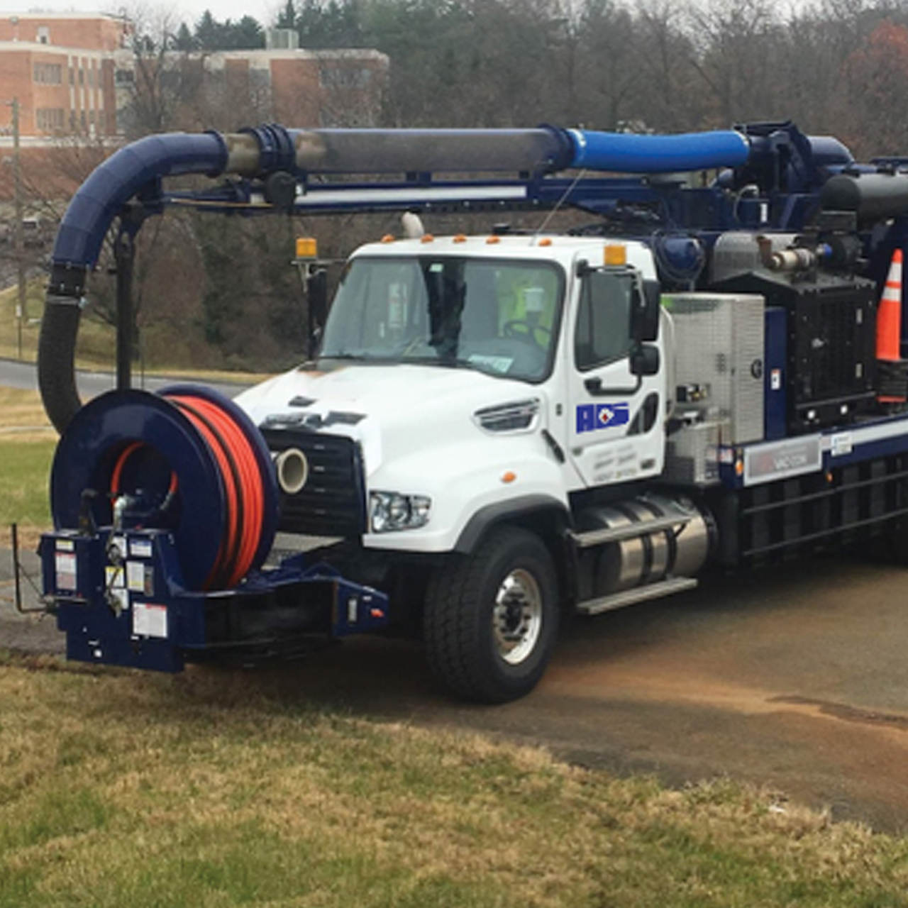 Industrial VAC services truck parked on grass.